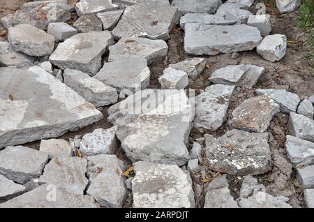 Stücke aus grauem Betonboden auf der Straße. Lehmschlamm. Stockfoto