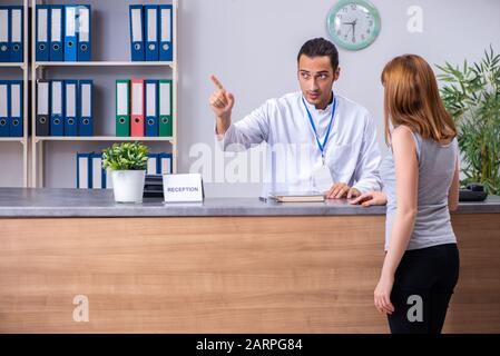 Die junge Patientin an der Rezeption im Krankenhaus Stockfoto