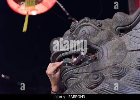 Hauptstadt Federal, Buenos Aires/Argentinien; 25. Januar 2020: Hand, die Geld in den Mund einer chinesischen Schutzgeld-Statue einführt, in den Feierlichkeiten Stockfoto