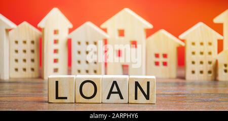Miniaturhäuser mit dem Wort Darlehen. Das Konzept der Hypothekenwohnungen und Immobilienkredite. Kaufen Sie eine Wohnung auf Kredit. Leasing. Erschwingliches Gehäuse für