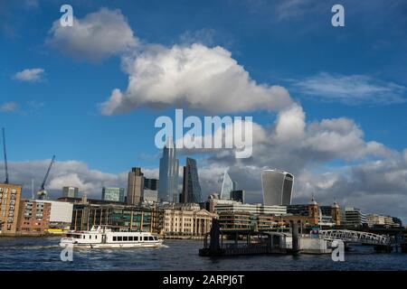 London - 28. JANUAR: Fußgänger überqueren die Millennium Bridge in London im Wintersonnenlicht, das auf die Kuppel der St. Paul's Cathedral scheint, während zwei Schwäne an der Themse vorbeiziehen. Foto: © 2020 David Levenson Stockfoto