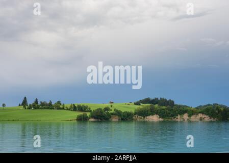 Ländliche Landschaft mit Wiesen, Wald und Klippen am Forggensee kurz nach Gewitter, im Allgäuer, Bayern, Deutschland Stockfoto