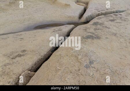 Hellgelber Hintergrund der Oberfläche der Felsoberfläche. Steinernes Meeresufer Stockfoto