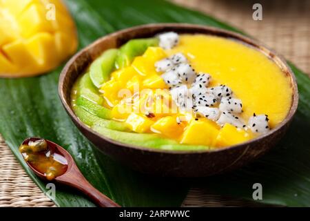 Mango-Smoothie-Schüssel mit Kiwi, Drachenobst und Passionsfrucht. Stockfoto