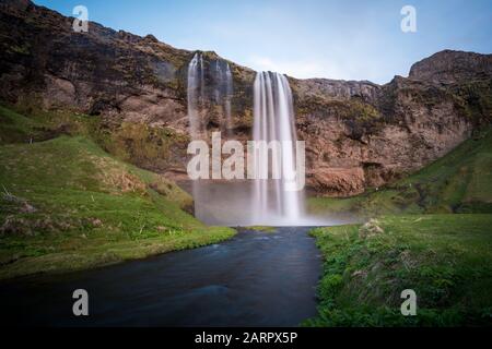 Seljalandsfoss Wasserfall lange Belichtung während eines hellen Sonnentags in Island Stockfoto