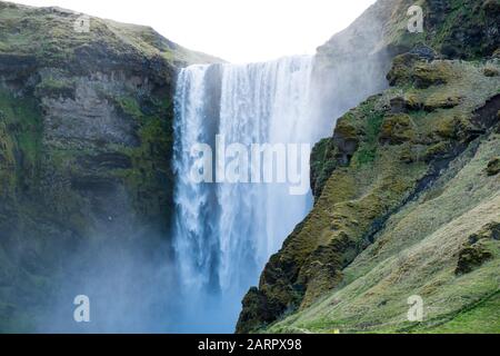Der Wasserfall Skógafoss, der an einem bewölkten Tag in Island an der berühmten Ringstraße mit großer Kraft fließt. Der Wasserfall ist einer der erstaunlichsten Ort Stockfoto