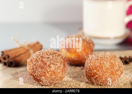 Leckere Donuts Löcher, die mit Zimtzucker auf dem braunen Papier auf dem Tisch bestreut wurden. Abstrakter Hintergrund wird gedikt. Horizontal . Stockfoto