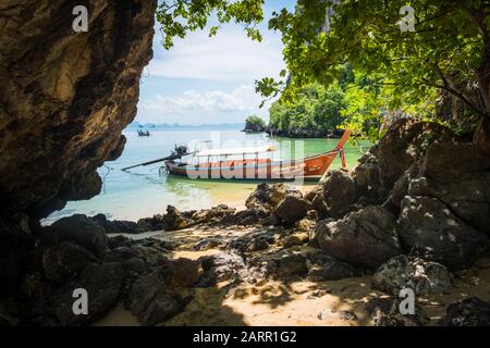 Verankertes thailändisches Langschwänzboot in der Phang Nga Bay, Thailand. Karstfelsenformationen in der Ferne Stockfoto