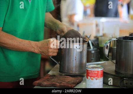 Barkeeper Mischen Sie den thailändischen Milchtee im Amphawa Floating Market. Stockfoto