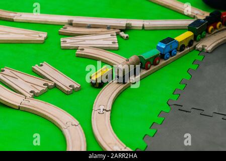 Spielzeugeisenbahn für Kinder. Holzelemente des Designers auf dem Boden. Stockfoto