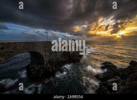 Ein Sonnenuntergang am alten Pier des Küstendorfes Ponta do Sol auf der Insel Madeira Stockfoto