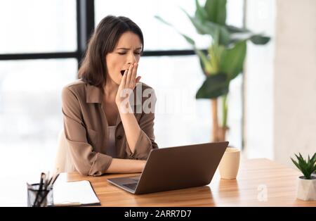 Der junge europäische Manager schwelt am Arbeitsplatz Stockfoto