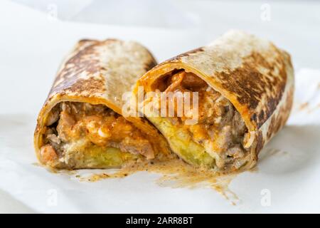 Mexikanischer Wrap Burrito mit Steakfilet, Guacamolesauce, Sauerkreme, Pico De Gallo, Mozzarella-Käse und Kartoffeln/kalifornischer Stil. Fast Food. Stockfoto