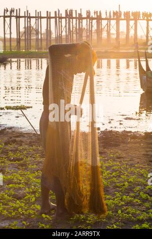 Fischer bereitet im Februar Netze von der U Bein-Brücke, Ubein-Brücke, über den Taungthaman-See, Amarapura, Mandalay, Myanmar (Birma), Asien vor Stockfoto