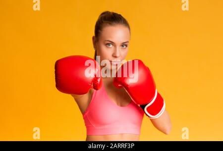 Junge Sportliche Frau Mit Roten Boxhandschuhen, Bereit Zum Angriff Stockfoto