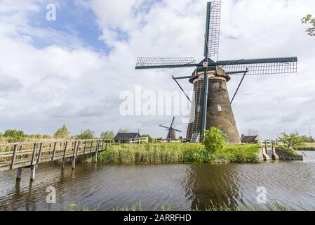 Reisen Sie in die Niederlande . traditionelle Niederlande - Windmühlen . Windmühlen bei Sonnenaufgang. Rustikale Landschaft mit traditionellen holländischen Windmühlen in der Nähe des Wasserkanals Stockfoto