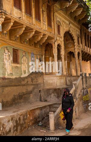 Indien, Rajasthan, Shekhawati, Nawalgarh, Podar Haveli Museum Road, Muslimin, die in schlechtem Zustand an dem historischen Haveli vorbeiläuft Stockfoto