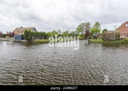 Reisen Sie in die Niederlande . traditionelle Niederlande - Windmühlen . Windmühlen bei Sonnenaufgang. Rustikale Landschaft mit traditionellen holländischen Windmühlen in der Nähe des Wasserkanals Stockfoto