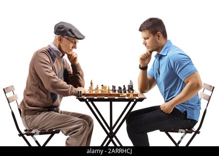 Ein älterer Mann und ein junger Mann, der Schach spielt, isoliert auf weißem Hintergrund Stockfoto