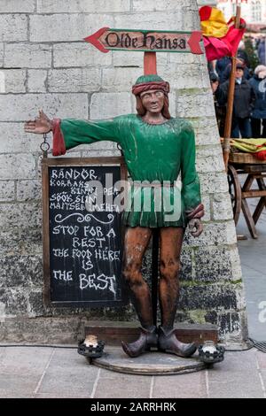 Antike handgeschnitzte Figur, die auf das Touristenrestaurant Olde Hansa (Altes Haus) in der Altstadt, Tallinn, Estland, hinweist Stockfoto