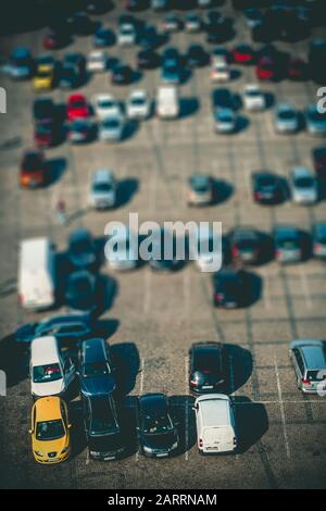 Großer Parkplatz mit vielen verschiedenen Autos, von oben gesehen, mit Neigungsschalteffekt Stockfoto