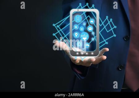 Geschäftsmann mit virtuellem Bildschirm auf dunklem Hintergrund, Nahaufnahme. Konzept der Geschäftsplanung Stockfoto