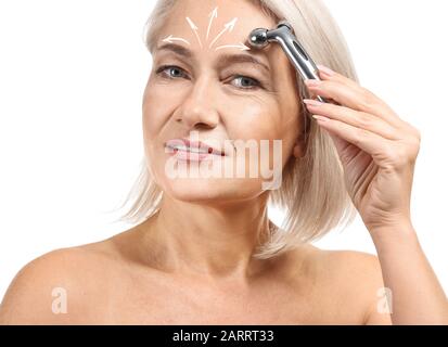 Reife Frau geben sich Massage auf weißem Hintergrund Gesicht Stockfoto