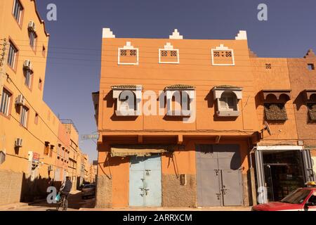 Ein modernes Stadthaus mit geschlossenen Geschäften im Untergeschoss der Stadt Tan Tan, Marokko. Elektrische Drähte entlang der Fassade des Hauses Stockfoto