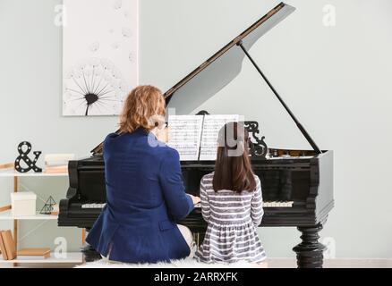 Der Mann, der dem kleinen Mädchen das Klavierspiel beigebracht hat Stockfoto