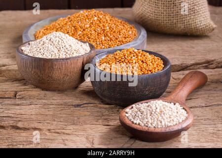 Quinoa Samen und rote Hirse in Schüssel auf rustikalem Holz Stockfoto