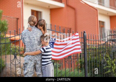 Traurige kleine Kinder verabschieden sich von ihrem Militärvater im Freien Stockfoto