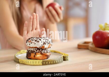 Frau, die sich weigert, ungesunde Donuts zu essen, Nahaufnahme. Diät-Konzept Stockfoto