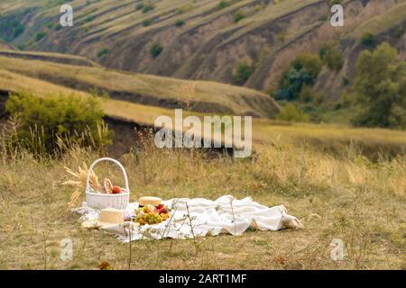 Stilvolle Sommer Picknick auf einer weißen Decke. In einem malerischen Ort der Natur der Hügel Stockfoto