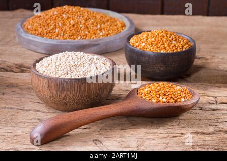 Quinoa Samen und rote Hirse in Schüssel auf rustikalem Holz Stockfoto