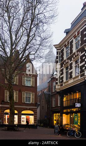 In Utrechter, Niederlande, 21. Januar 2020. Das Zentrum von Utrechter. Nebliger Abend, Blick auf die Nacht der Geschäfte, alte holländische Häuser, Fahrräder entlang der Straße. Stockfoto