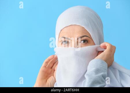 Schöne reife Muslimin auf Farbhintergrund Stockfoto