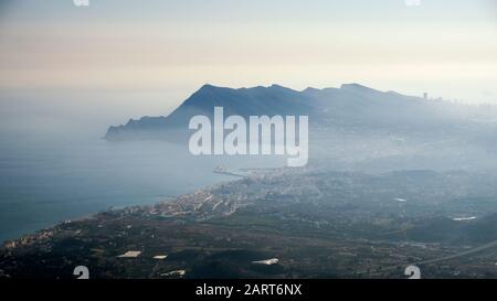 Altea-Stadt mit der Serra Gelada Bergkette im Hintergrund in einer Dunstumgebung (Marina Baixa, Costa Blanca, Alicante, Valencianische Gemeinschaft, Spanien) Stockfoto