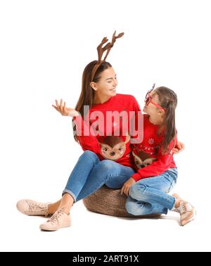 Lustige junge Frau und ihre Tochter in Weihnachts-Pullover auf weißem Hintergrund Stockfoto