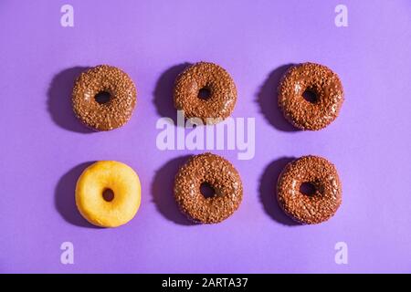 Leckere Donuts auf Farbhintergrund. Konzept der Einzigartigkeit Stockfoto