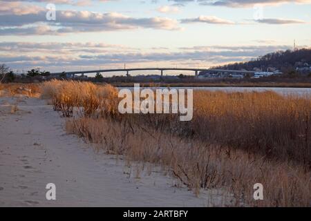 Sandy Hook Bay wird von der untergehenden Sonne beleuchtet und beleuchtet das goldene Gras in Highlands, New Jersey, USA -01 Stockfoto