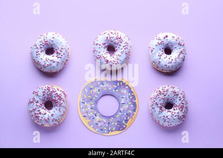 Leckere Donuts auf Farbhintergrund. Konzept der Einzigartigkeit Stockfoto