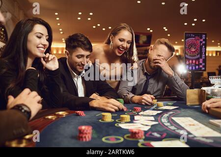 Eine Gruppe wohlhabender Jugendlicher spielt in einem Casino. Stockfoto