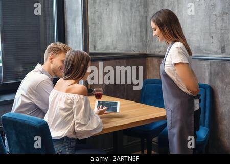 Kellnerin, die Kunden im Restaurant bedient Stockfoto