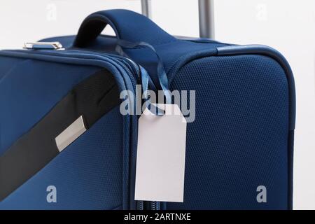 Leeres Gepäckaufkleber auf blauem Koffer Stockfoto