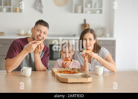 Glückliche Familie Pizza zu Hause essen Stockfoto