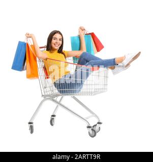 Junge Frau mit Einkaufswagen und Taschen auf weißem Hintergrund Stockfoto