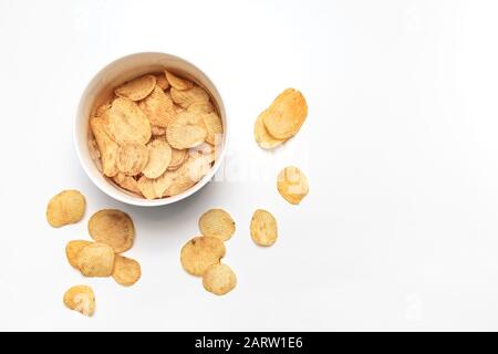 Kartoffelchips und Schüssel auf weißem Hintergrund. Junk-Food-Konzept. Draufsicht. Flaches Lay Stockfoto