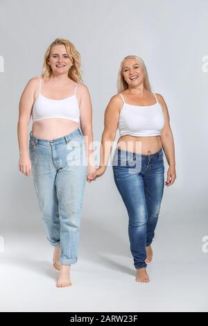 Portrait von körperpositiven Frauen auf grauem Hintergrund Stockfoto