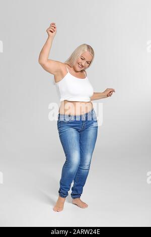 Reife körperpositive Frau auf grauem Hintergrund Stockfoto