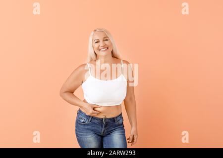 Portrait von fälligen Körper positive Frau auf farbigen Hintergrund Stockfoto